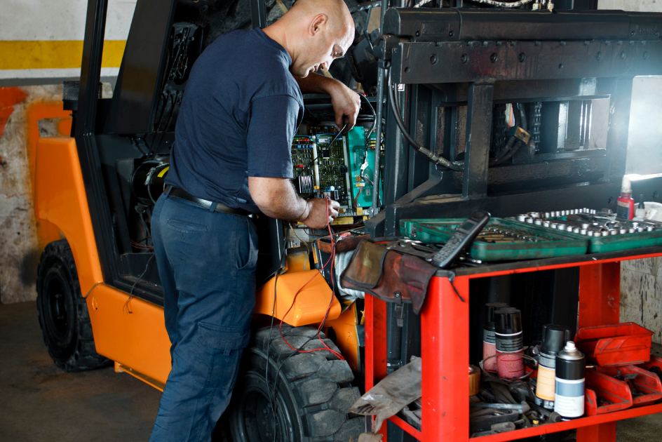 man working on forklift